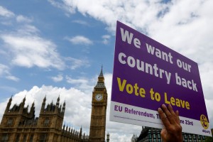 A demonstrator for the "Leave" campaign holds a placard outside Houses of Parliament in London, U.K., on Wednesday, June 15, 2016. The Brexit battle took to London's River Thames as boats supporting the "Leave" and "Remain" campaigns jostled for space, while Irish rock star Bob Geldof harangued U.K. Independence Party leader Nigel Farage using a sound system. Photographer: Luke MacGregor/Bloomberg via Getty Images