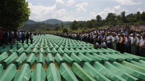 Bosnian people pray near coffins of Srebrenica victims, during amass funeral in Potocari 120 km northeast of Sarajevo, Bosnia, on Sunday, July 11, 2010. Weeping among endless rows of coffins, tens of thousands gathered Sunday in the eastern Bosnian town of Srebrenica to bury hundreds of massacre victims on the 15th anniversary of the worst crime in Europe since the Nazi era. (AP Photo/Amel Emric)